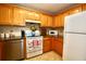 Cozy kitchen featuring stainless steel dishwasher, granite countertops, and warm cabinetry at 6150 Gulfport S Blvd # 302, Gulfport, FL 33707