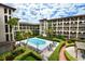 Community pool surrounded by lounge chairs, landscaped gardens, and elegant architecture at 6150 Gulfport S Blvd # 302, Gulfport, FL 33707
