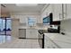 Modern kitchen with white cabinets, stainless steel appliances, and tile flooring at 6212 Emerson Dr, New Port Richey, FL 34653