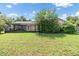 Expansive backyard featuring a screened lanai and lush greenery at 6436 Huntington Dr, Zephyrhills, FL 33542