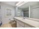 Bright bathroom featuring a large mirror, a commode, and an arched window with shutters at 6436 Huntington Dr, Zephyrhills, FL 33542