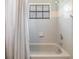 This bathroom features a tub with grey tiling and a showerhead at 6436 Huntington Dr, Zephyrhills, FL 33542