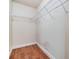 Walk-in closet featuring built-in shelving and hardwood floors at 6436 Huntington Dr, Zephyrhills, FL 33542