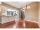 Dining room with wood floors, and adjacent kitchen featuring white cabinets at 6436 Huntington Dr, Zephyrhills, FL 33542