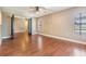 Spacious living room with beautiful hardwood floors, ceiling fan, and window with natural light at 6436 Huntington Dr, Zephyrhills, FL 33542