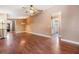 Open living room with wood floors, a ceiling fan and connecting rooms at 6436 Huntington Dr, Zephyrhills, FL 33542