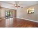 Bright living room featuring hardwood floors, ceiling fan, and glass doors to outdoor seating area at 6436 Huntington Dr, Zephyrhills, FL 33542