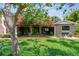 Charming backyard featuring a covered patio with mature landscaping and brick flooring at 750 Alda Ne Way, St Petersburg, FL 33704