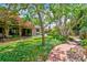 Serene backyard setting with lush greenery, mature trees, and a winding brick path at 750 Alda Ne Way, St Petersburg, FL 33704