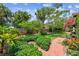 Lush backyard with manicured landscaping, mature trees, and a winding brick pathway at 750 Alda Ne Way, St Petersburg, FL 33704