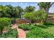 Landscaped backyard featuring a charming wooden bridge and brick pathway at 750 Alda Ne Way, St Petersburg, FL 33704