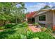 Lush backyard featuring a brick path, healthy lawn, and mature trees for shade at 750 Alda Ne Way, St Petersburg, FL 33704