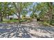 Front exterior of a home with mature trees, lush landscaping, and a paved driveway at 750 Alda Ne Way, St Petersburg, FL 33704