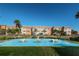 Beautiful exterior view of building with palm trees and a decorative water feature under a clear blue sky at 8 Glencoe Pl # 305, Dunedin, FL 34698
