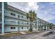 Multi-story condo building featuring private balconies and well-maintained landscaping at 8 Glencoe Pl # 305, Dunedin, FL 34698
