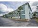 Bright condominium complex featuring a well-maintained exterior with palm trees and an inviting entrance at 8 Glencoe Pl # 305, Dunedin, FL 34698