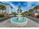 Picturesque fountain adorned with flamingo statues, set amidst lush landscaping at the property entrance at 8 Glencoe Pl # 305, Dunedin, FL 34698