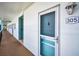 Exterior hallway view of unit 305, showing the entrance, outdoor lighting and secure doorway at 8 Glencoe Pl # 305, Dunedin, FL 34698