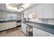 Well-lit kitchen featuring white cabinets, built-in desk, and tiled flooring at 8 Glencoe Pl # 305, Dunedin, FL 34698