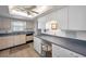 Functional kitchen with white cabinets and countertop desk area; offers ample lighting at 8 Glencoe Pl # 305, Dunedin, FL 34698