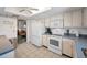 Well-lit kitchen featuring white appliances, cabinets, and tile flooring for a clean aesthetic at 8 Glencoe Pl # 305, Dunedin, FL 34698