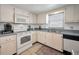 Bright kitchen with white appliances, tile floors, and natural light from the window above the sink at 8 Glencoe Pl # 305, Dunedin, FL 34698