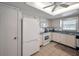 Spacious kitchen with white cabinets, appliances, and a window offering natural light at 8 Glencoe Pl # 305, Dunedin, FL 34698