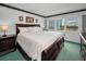 Comfortable primary bedroom with a large window and ample natural light and carpet at 8 Glencoe Pl # 305, Dunedin, FL 34698