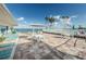 Outdoor patio with tables, chairs, lounge chairs, and umbrellas overlooking the ocean at 8 Glencoe Pl # 305, Dunedin, FL 34698