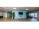 Spacious recreation room with tile flooring, a large TV, and seating overlooking the water at 8 Glencoe Pl # 305, Dunedin, FL 34698