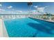 Community swimming pool with chairs, umbrellas, and an ocean view for relaxation and leisure at 8 Glencoe Pl # 305, Dunedin, FL 34698
