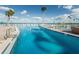 Community swimming pool with clear blue water and plenty of lounge chairs on the deck at 8 Glencoe Pl # 305, Dunedin, FL 34698