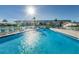 Outdoor community swimming pool with sparkling water, tables, chairs and lounge areas for guests at 8 Glencoe Pl # 305, Dunedin, FL 34698