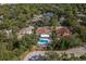 Aerial view of home with beautiful pool, lush landscaping, and surrounding neighborhood at 8240 144Th Ln, Seminole, FL 33776