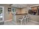 Home wet bar with bar seating, natural light, and views of the backyard and pool at 8240 144Th Ln, Seminole, FL 33776