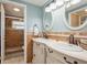 Bathroom showcasing double sinks, oval mirrors and a walk-in shower with brown tile at 8240 144Th Ln, Seminole, FL 33776