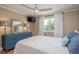 Bedroom features a queen bed, mounted TV and a large window with natural light at 8240 144Th Ln, Seminole, FL 33776