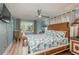 Bedroom features a light blue wall and tropical-patterned bed coverings, a ceiling fan, and natural light at 8240 144Th Ln, Seminole, FL 33776