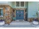Charming front door with rock surround, 'welcome' sign, and potted plants at 8240 144Th Ln, Seminole, FL 33776