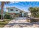 Beautiful exterior of home with circular driveway, stone accents, mature landscaping, and blue skies at 8240 144Th Ln, Seminole, FL 33776