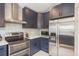 The kitchen features stainless steel appliances, decorative tile backsplash, and navy cabinets at 8240 144Th Ln, Seminole, FL 33776