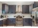 Modern kitchen boasts stainless steel appliances, double oven, blue cabinets, and quartz countertops at 8240 144Th Ln, Seminole, FL 33776