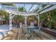Backyard pergola with outdoor seating, wood deck, and lush greenery all around at 8240 144Th Ln, Seminole, FL 33776