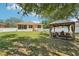 Serene backyard featuring lush green lawn, privacy fence, and cozy gazebo at 9917 Prevatt St, Gibsonton, FL 33534
