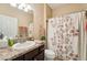 Well-maintained bathroom featuring a vanity, mirror, and tiled shower with curtain at 9917 Prevatt St, Gibsonton, FL 33534