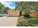Inviting single-story home features a beige stucco exterior, two-car garage, and an American flag displayed at 9917 Prevatt St, Gibsonton, FL 33534
