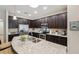 Modern kitchen with stainless steel appliances, granite countertops, and dark wood cabinetry at 9917 Prevatt St, Gibsonton, FL 33534