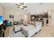 Spacious living room featuring tile flooring, ceiling fan and view into kitchen and dining area at 9917 Prevatt St, Gibsonton, FL 33534