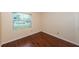 Cozy bedroom with wood-look flooring and a window, offering a bright and comfortable space for rest and relaxation at 10051 82Nd Ln, Seminole, FL 33777