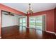 Open dining room with wood floors, sliding glass doors leading to a screened patio for outdoor living and entertainment at 10051 82Nd Ln, Seminole, FL 33777